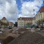 Eine Großbaustelle auf dem Rathausplatz in Herford mit Schutthaufen, Baggern und Absperrungen vor dem historischen Rathausgebäude.