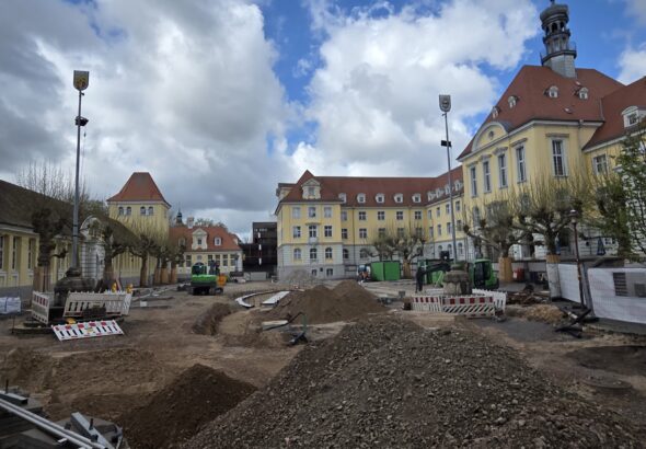 Eine Großbaustelle auf dem Rathausplatz in Herford mit Schutthaufen, Baggern und Absperrungen vor dem historischen Rathausgebäude.