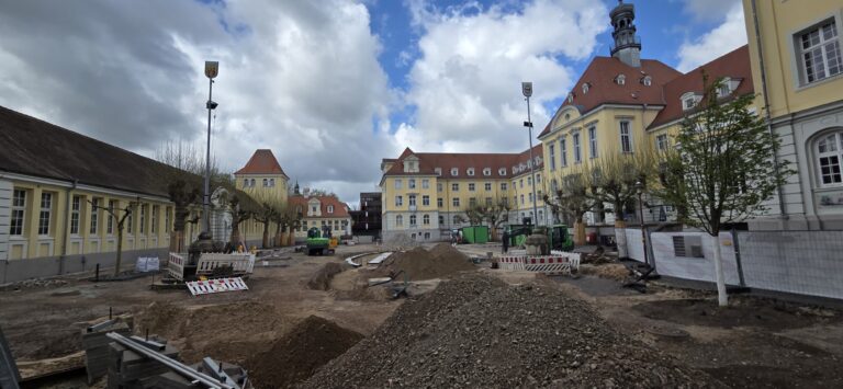 Eine Großbaustelle auf dem Rathausplatz in Herford mit Schutthaufen, Baggern und Absperrungen vor dem historischen Rathausgebäude.